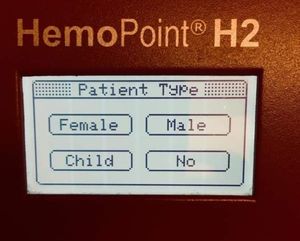 A photo of a HemoPoint H2 device LCD screen with &quot;Patient Type&quot; and selectable options for &quot;Female&quot;, &quot;Male&quot;, &quot;Child&quot;, &quot;No&quot;